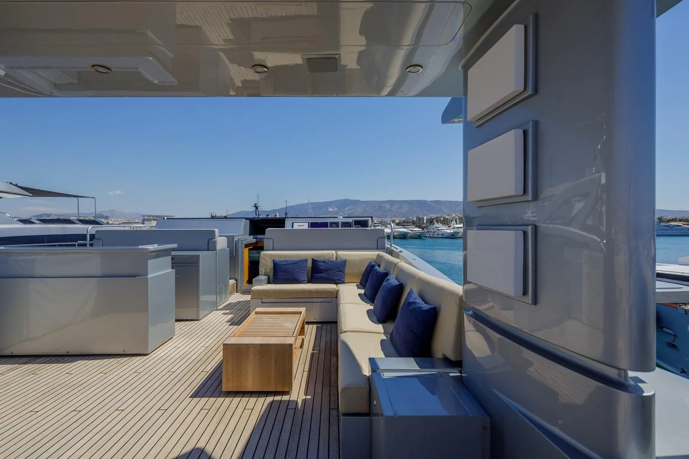 The aft deck features a spacious seating area with plush cushions and a wooden coffee table, perfect for relaxation and socializing. aboard BOLARO Yacht for Sale