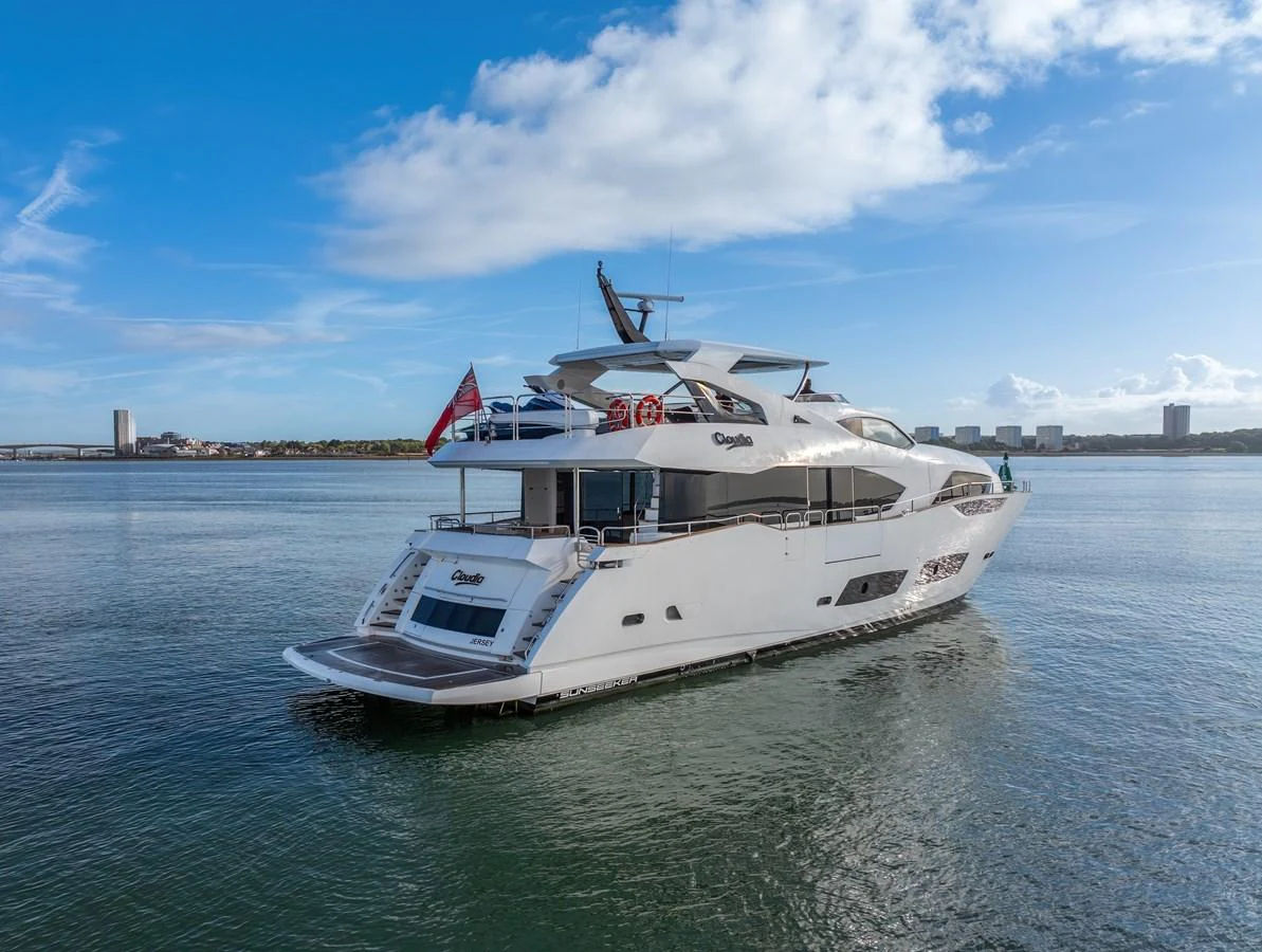 A luxurious yacht is anchored in calm waters under a bright blue sky. aboard CLOUDIA Yacht for Sale