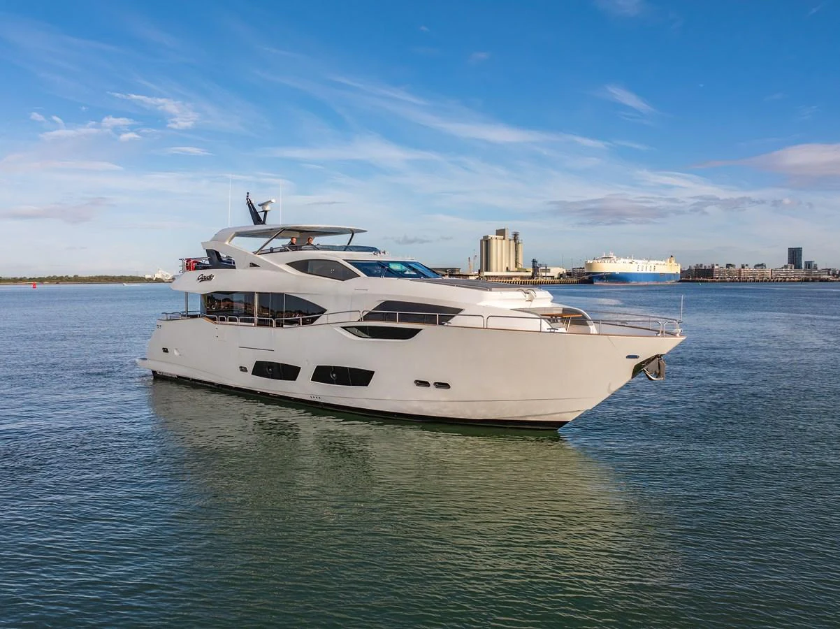 A sleek and modern yacht glides gracefully on calm waters under a clear blue sky. aboard CLOUDIA Yacht for Sale