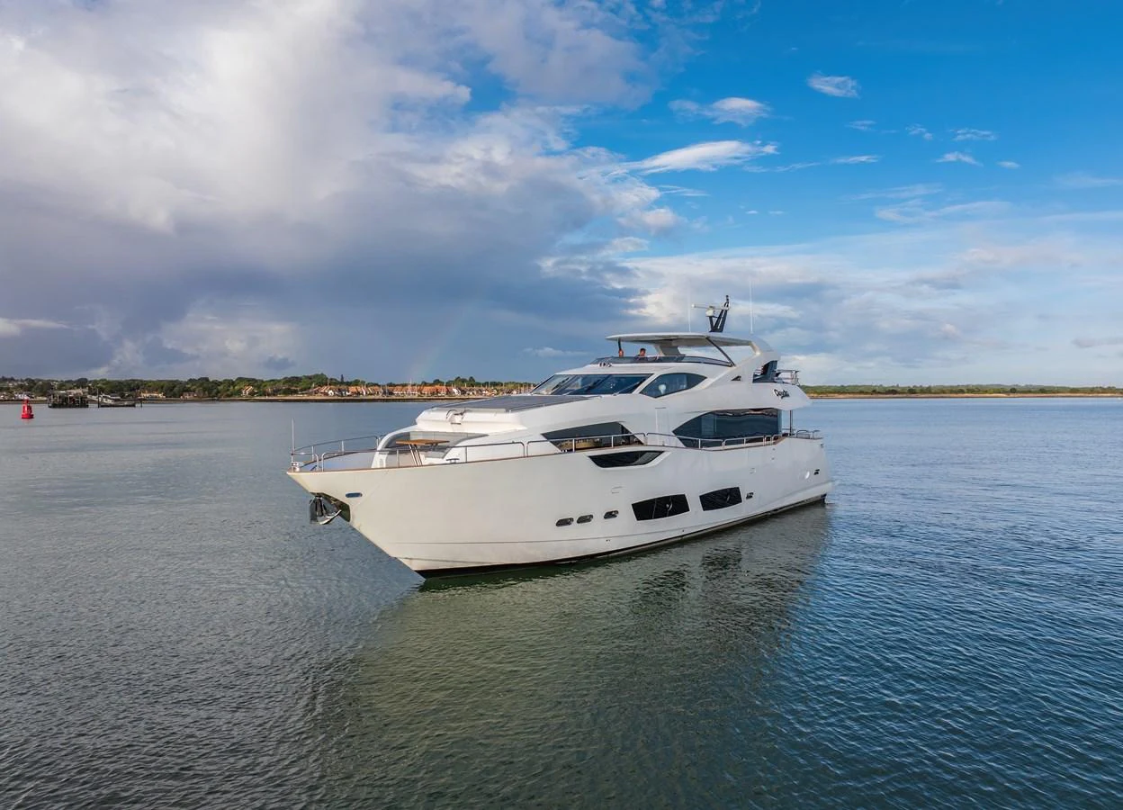 The yacht glides gracefully on calm waters under a clear blue sky. aboard CLOUDIA Yacht for Sale