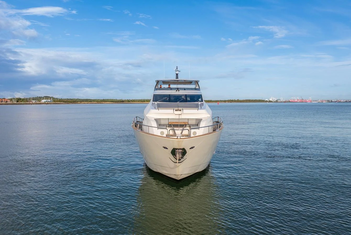 A luxurious yacht is anchored on calm waters under a clear blue sky. aboard CLOUDIA Yacht for Sale