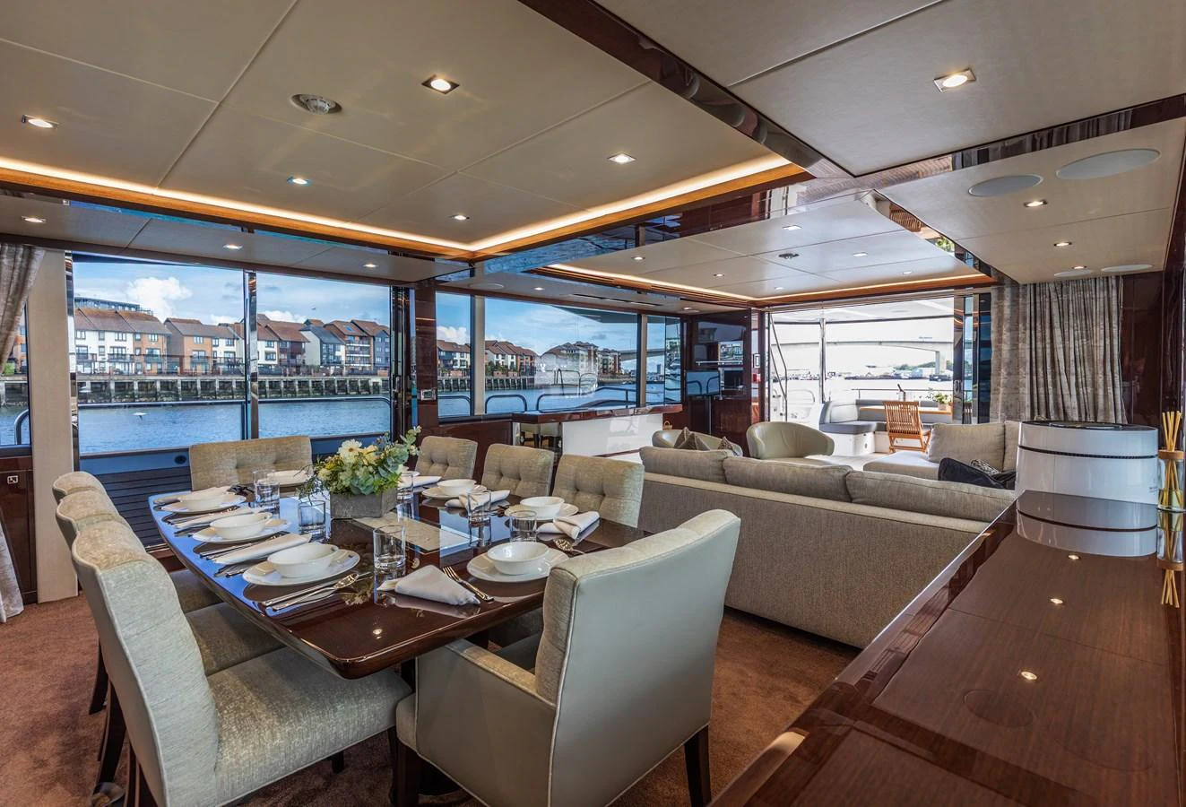 The yacht's salon features an elegant dining area and a comfortable lounge with panoramic views. aboard CLOUDIA Yacht for Sale
