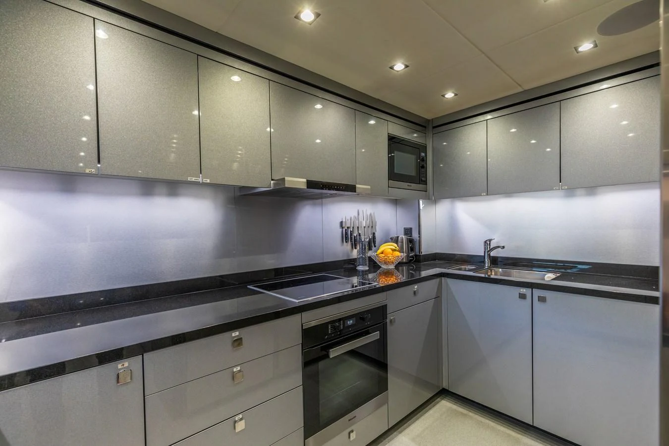 The yacht's galley features sleek modern cabinetry and high-end appliances. aboard CLOUDIA Yacht for Sale