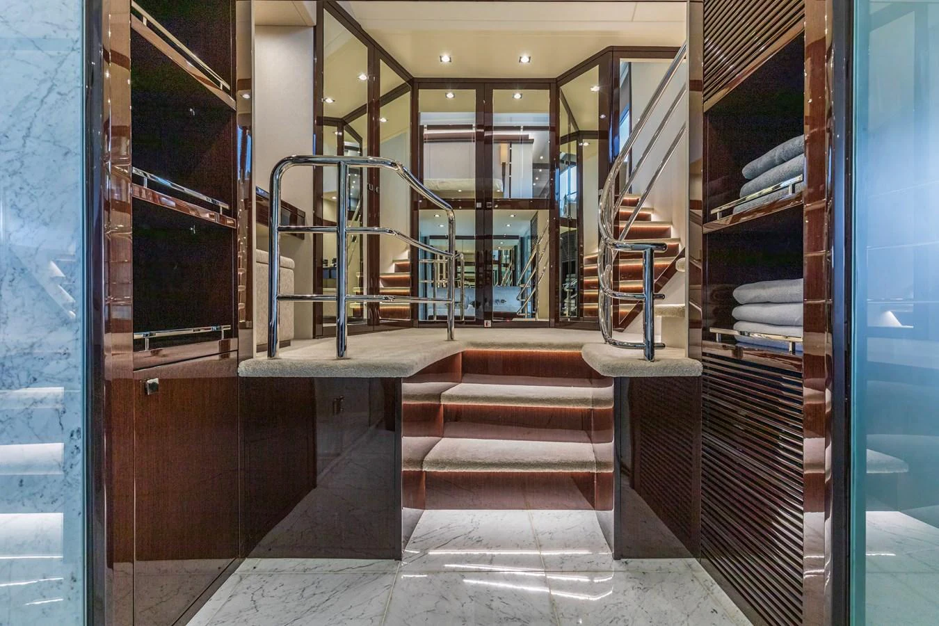 The yacht's interior features a luxurious staircase with elegant marble flooring and ample storage space. aboard CLOUDIA Yacht for Sale