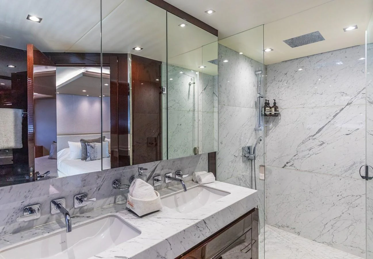 The yacht's bathroom features a luxurious marble finish with modern fixtures and a spacious shower area. aboard CLOUDIA Yacht for Sale