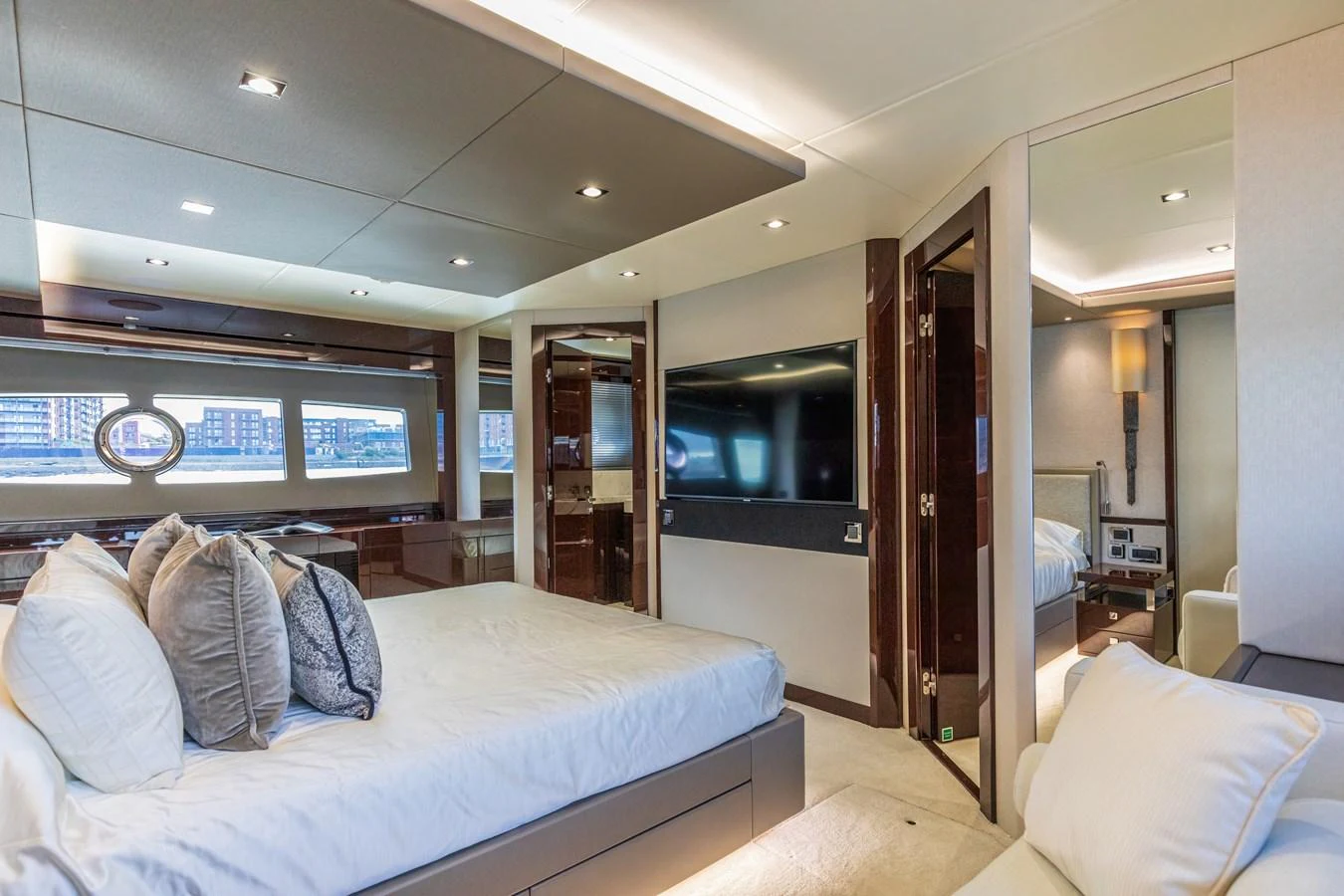 The master stateroom features a luxurious bed, ample seating, and modern entertainment amenities. aboard CLOUDIA Yacht for Sale