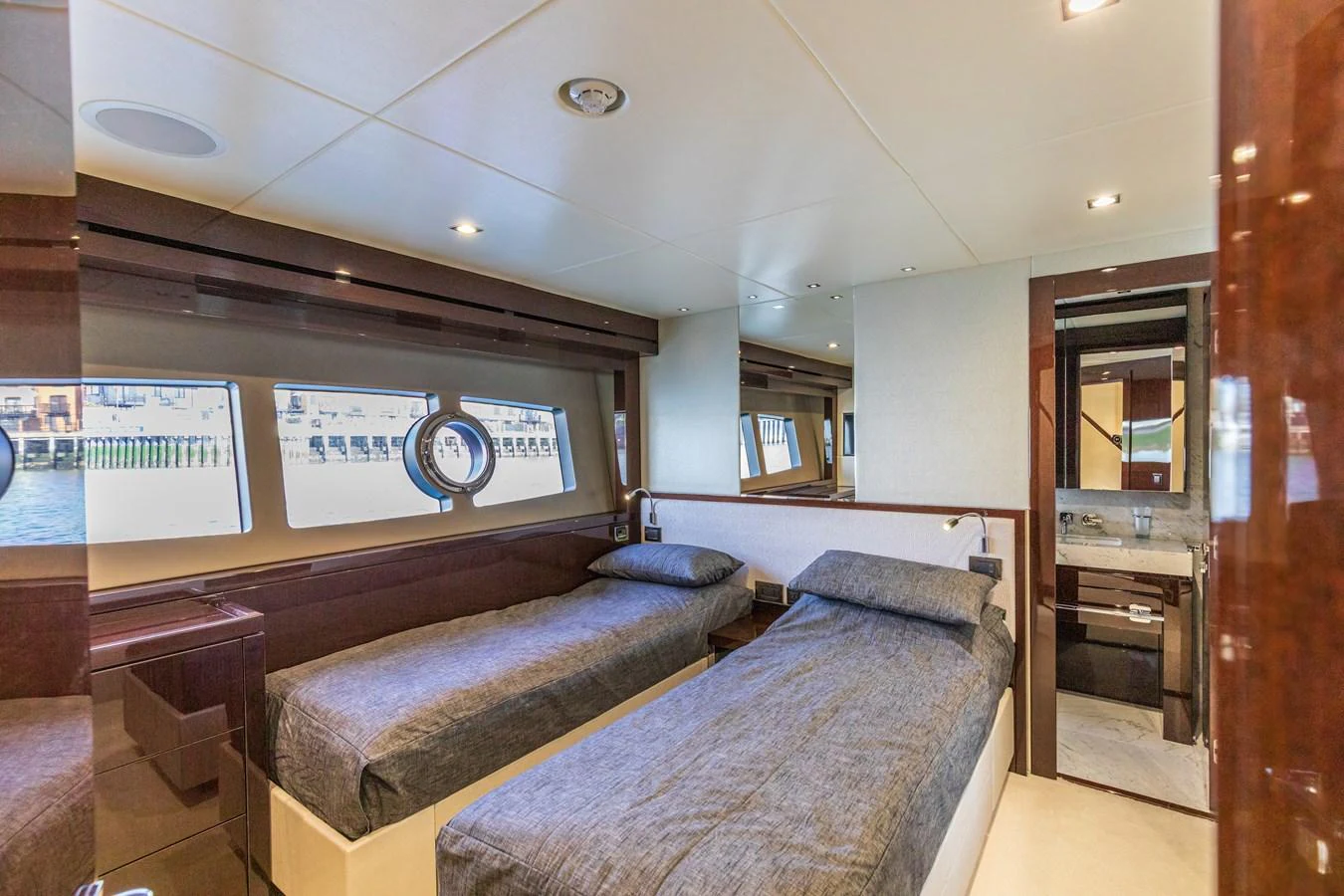 The twin stateroom offers comfortable sleeping arrangements with a view of the water through large windows. aboard CLOUDIA Yacht for Sale