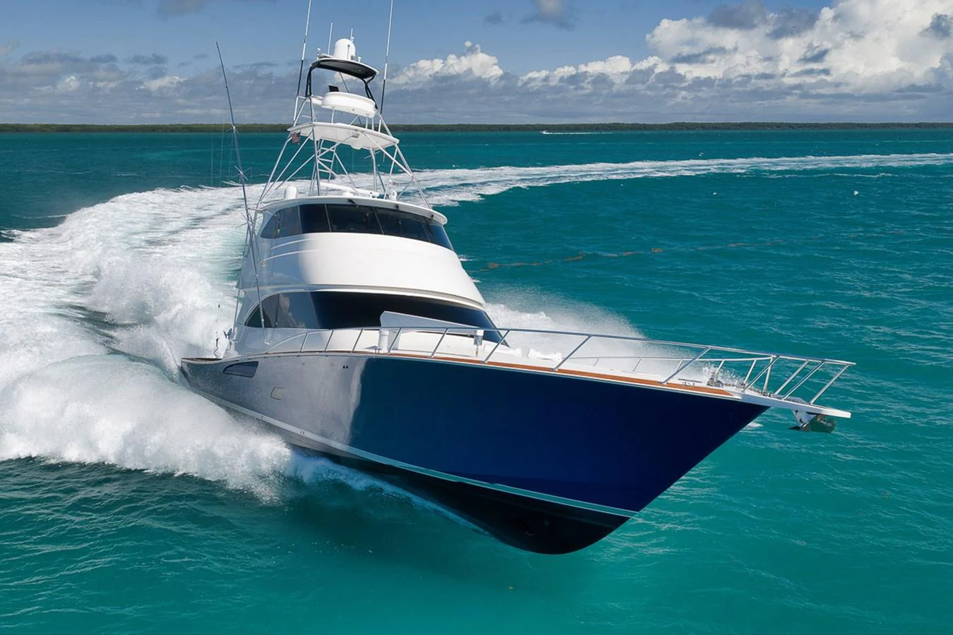 A sleek yacht cuts through the turquoise waters, showcasing its powerful design and elegant lines. aboard REEL HAWK Yacht for Sale