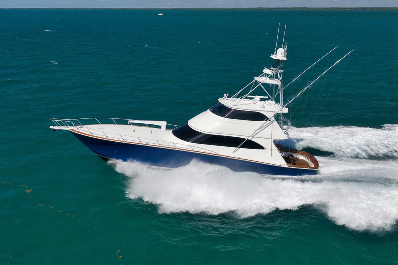 A sleek yacht cruises swiftly through turquoise waters, showcasing its elegant design and powerful performance. aboard REEL HAWK Yacht for Sale