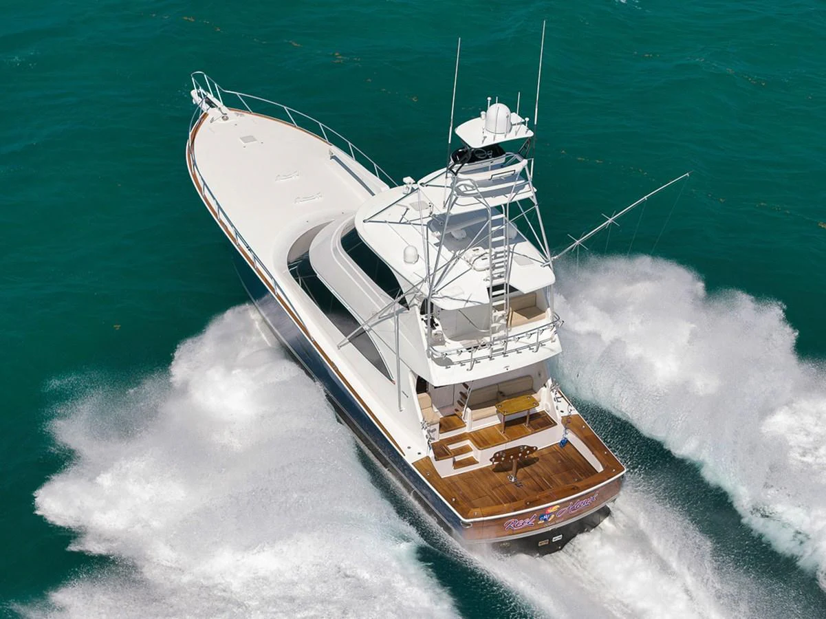 A sleek yacht cruises swiftly through clear turquoise waters, showcasing its elegant design and powerful performance. aboard REEL HAWK Yacht for Sale