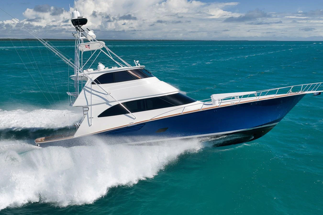 A sleek yacht cuts through the vibrant blue waters, showcasing its elegant design and powerful performance. aboard REEL HAWK Yacht for Sale
