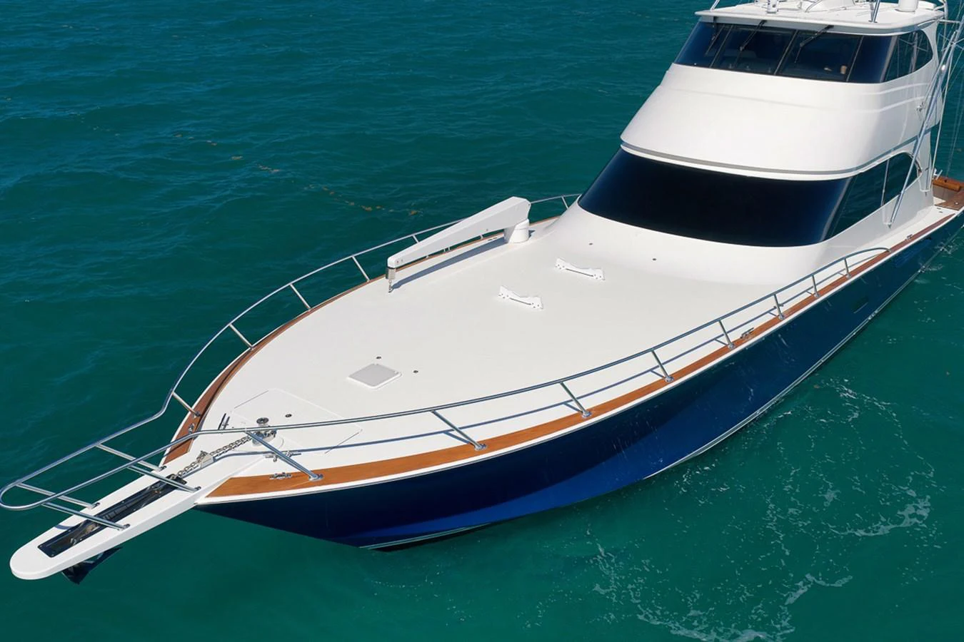 A sleek yacht glides gracefully on clear blue waters, showcasing its elegant design and spacious deck. aboard REEL HAWK Yacht for Sale