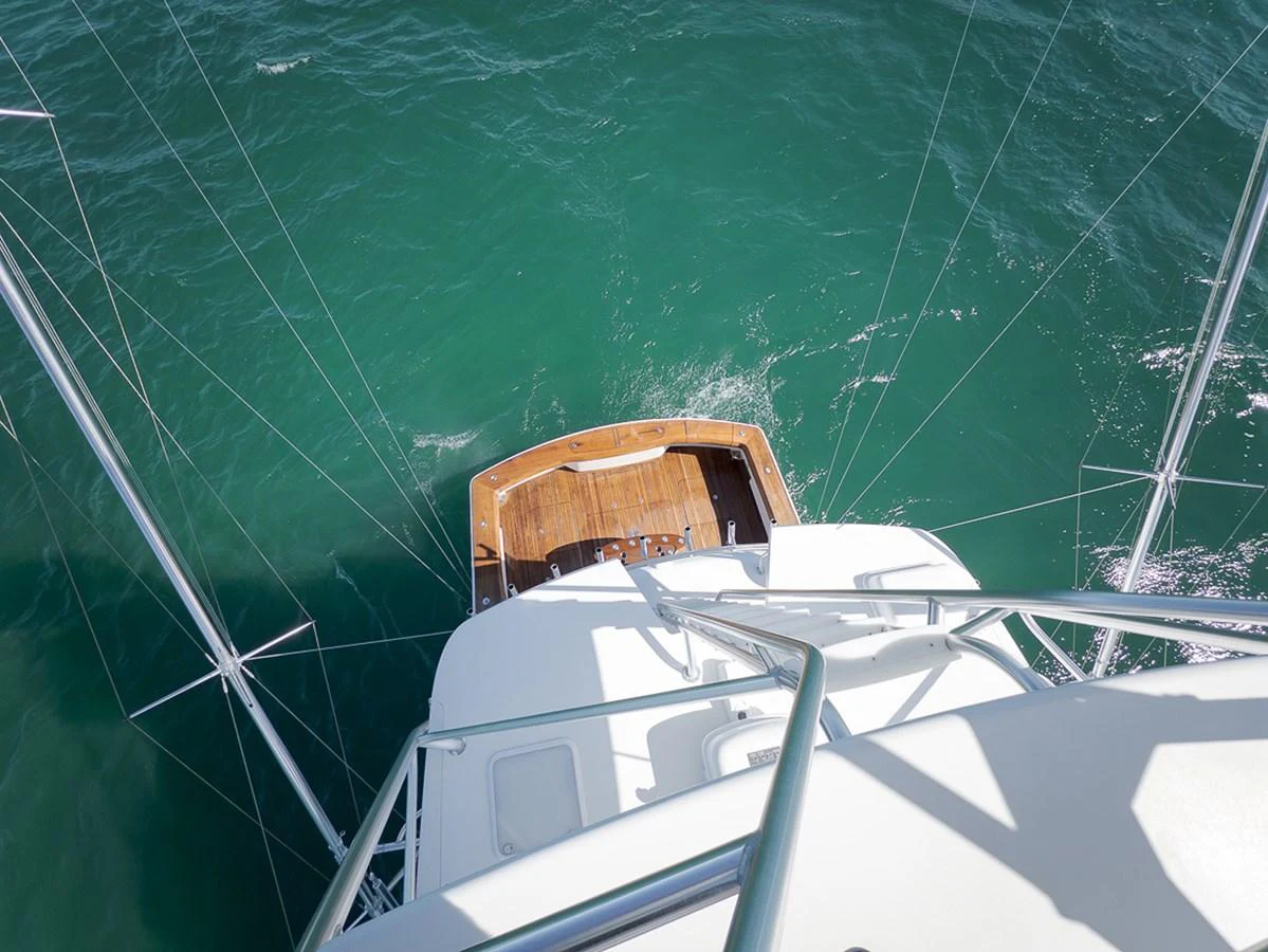 A view from above showcasing the stern of the yacht with a teak swim platform and surrounding ocean waters. aboard REEL HAWK Yacht for Sale