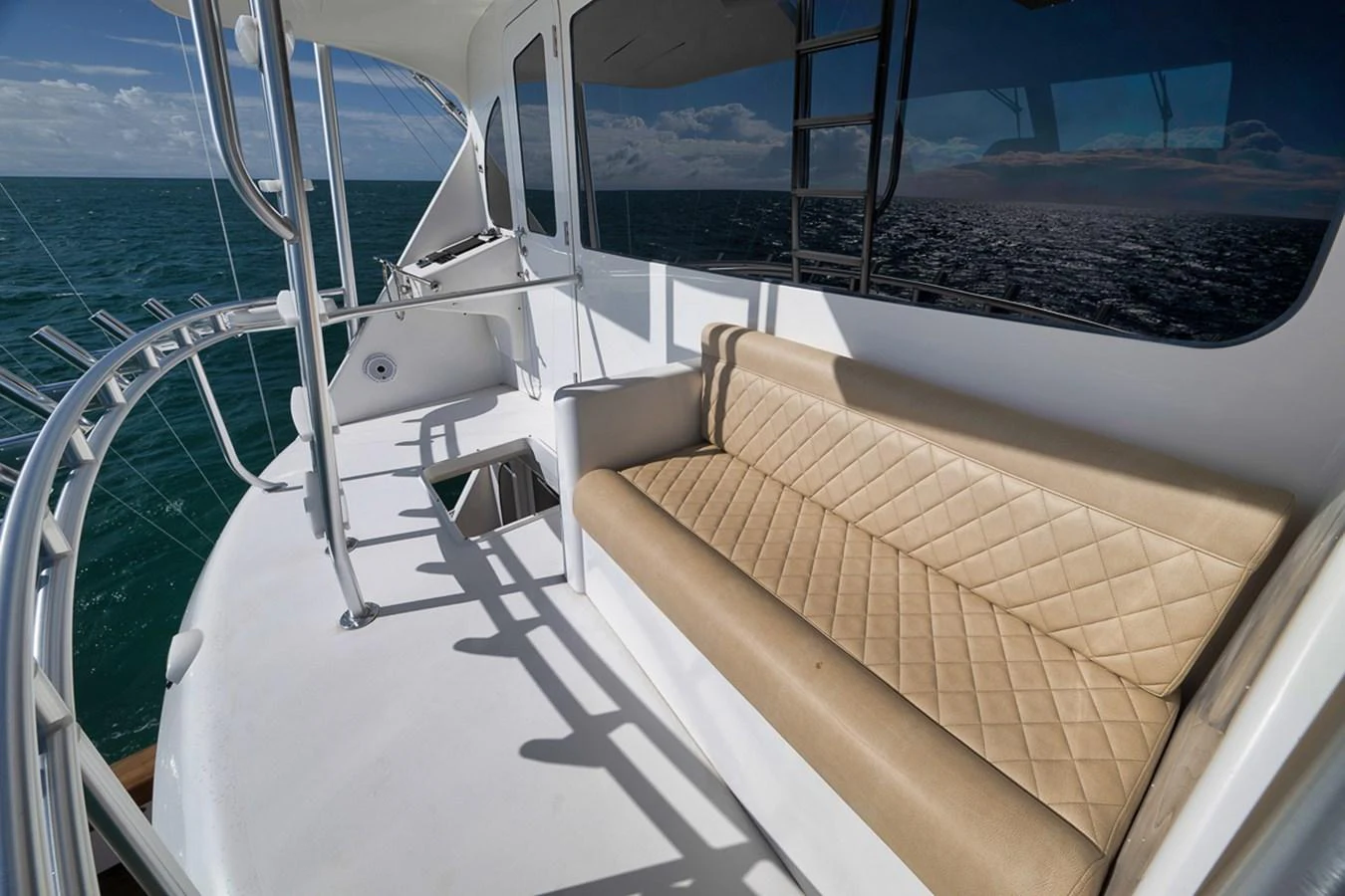 The aft deck features a comfortable seating area with a stunning view of the open sea. aboard REEL HAWK Yacht for Sale