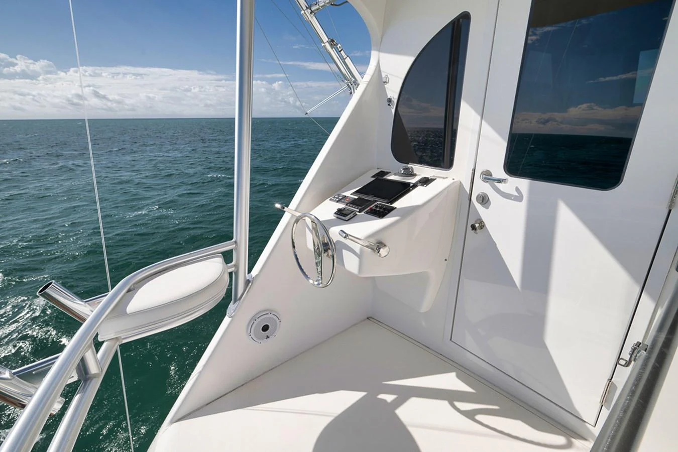 A sleek and modern helm station with a stunning ocean view. aboard REEL HAWK Yacht for Sale
