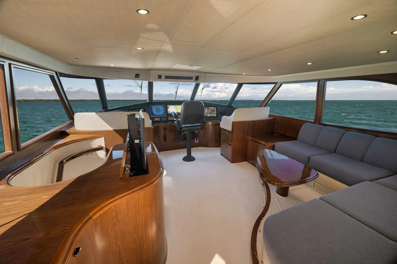 The helm area features a spacious seating arrangement with panoramic views of the sea. aboard REEL HAWK Yacht for Sale