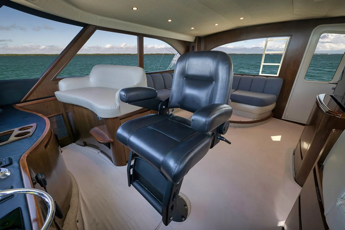 The helm area features a luxurious captain's chair with a panoramic view of the sea. aboard REEL HAWK Yacht for Sale