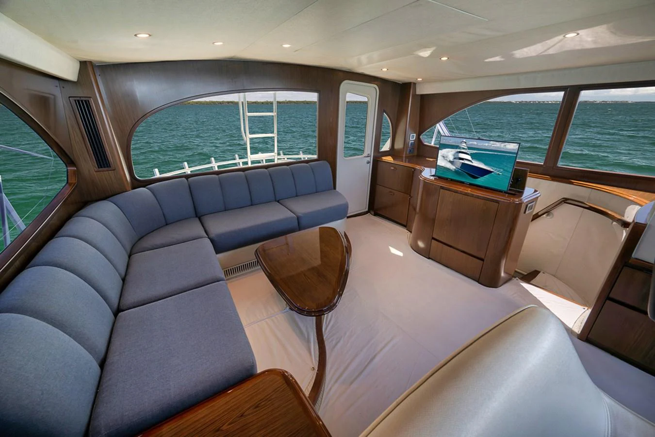 The salon features a spacious seating area with panoramic windows offering stunning sea views. aboard REEL HAWK Yacht for Sale