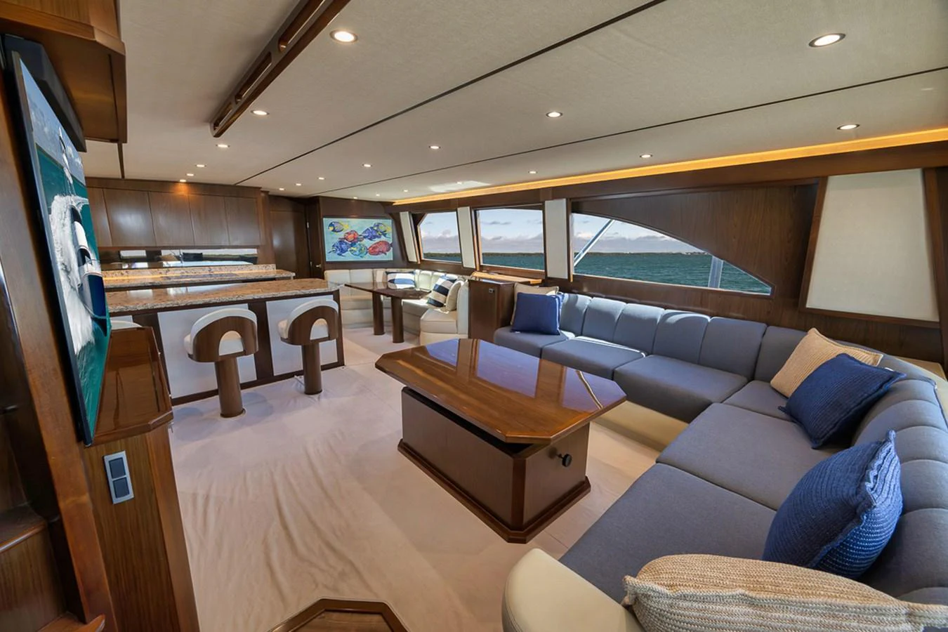 The yacht's salon features a spacious and elegant seating area with large windows offering stunning ocean views. aboard REEL HAWK Yacht for Sale