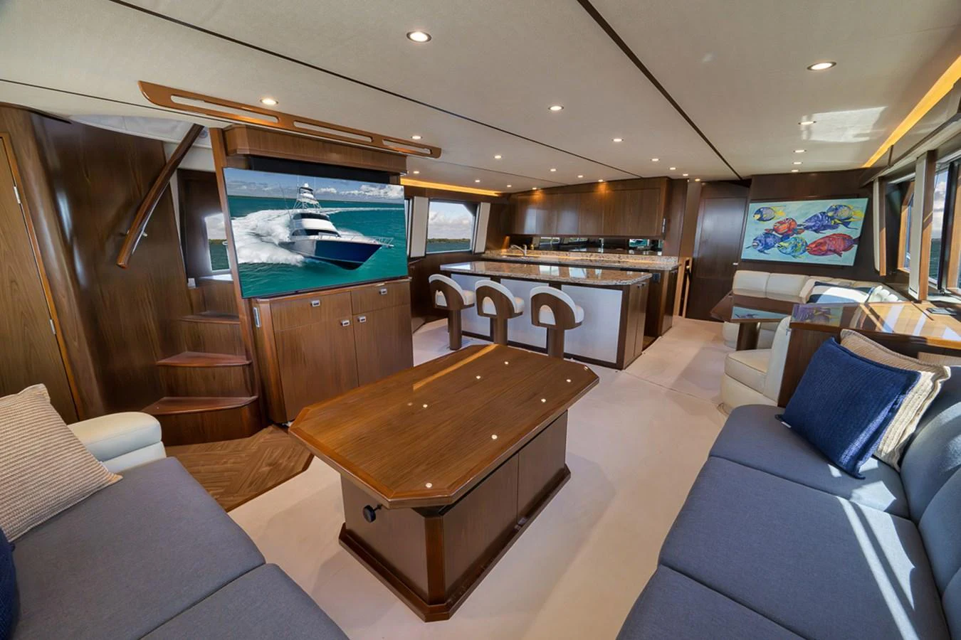 The yacht's salon features elegant wood finishes, plush seating, and a large flat-screen TV, creating a luxurious and inviting atmosphere. aboard REEL HAWK Yacht for Sale