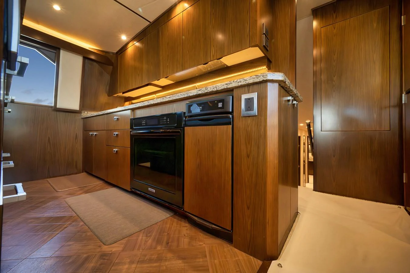 The yacht's galley features modern appliances and elegant wood cabinetry, creating a warm and functional space for meal preparation. aboard REEL HAWK Yacht for Sale