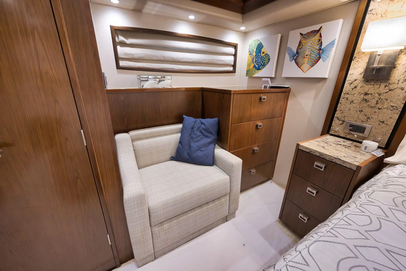 A cozy seating area in a yacht's cabin, featuring a comfortable armchair and stylish wooden cabinetry. aboard REEL HAWK Yacht for Sale