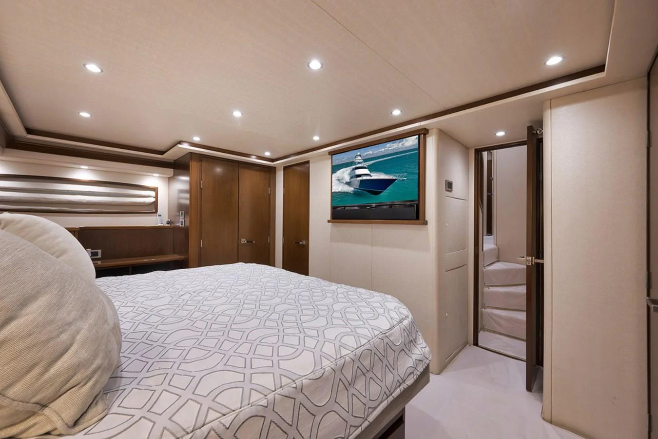 The stateroom features a luxurious bed, ambient lighting, and a flat-screen TV for ultimate relaxation. aboard REEL HAWK Yacht for Sale