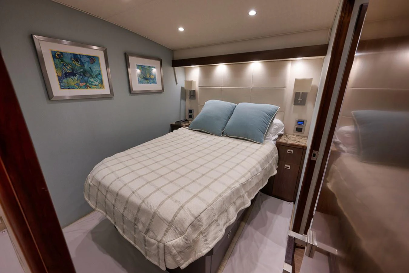 The stateroom features a cozy bed with elegant decor and soft lighting. aboard REEL HAWK Yacht for Sale