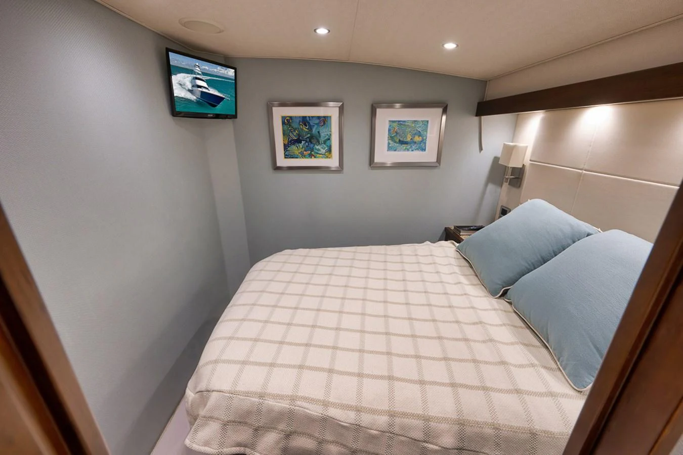 The guest stateroom features a cozy bed with soft linens and tasteful artwork on the walls. aboard REEL HAWK Yacht for Sale