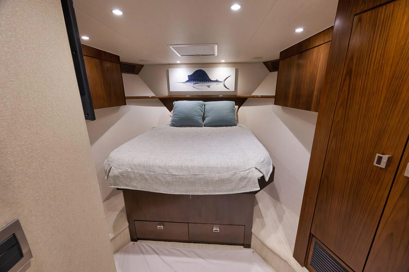 A cozy stateroom featuring a comfortable bed and elegant wooden cabinetry. aboard REEL HAWK Yacht for Sale