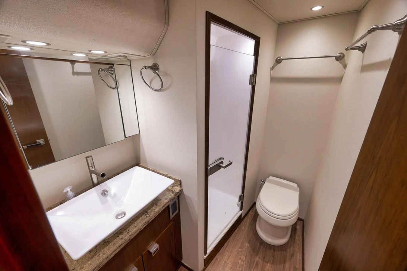 A well-appointed yacht bathroom featuring a modern sink, toilet, and enclosed shower. aboard REEL HAWK Yacht for Sale
