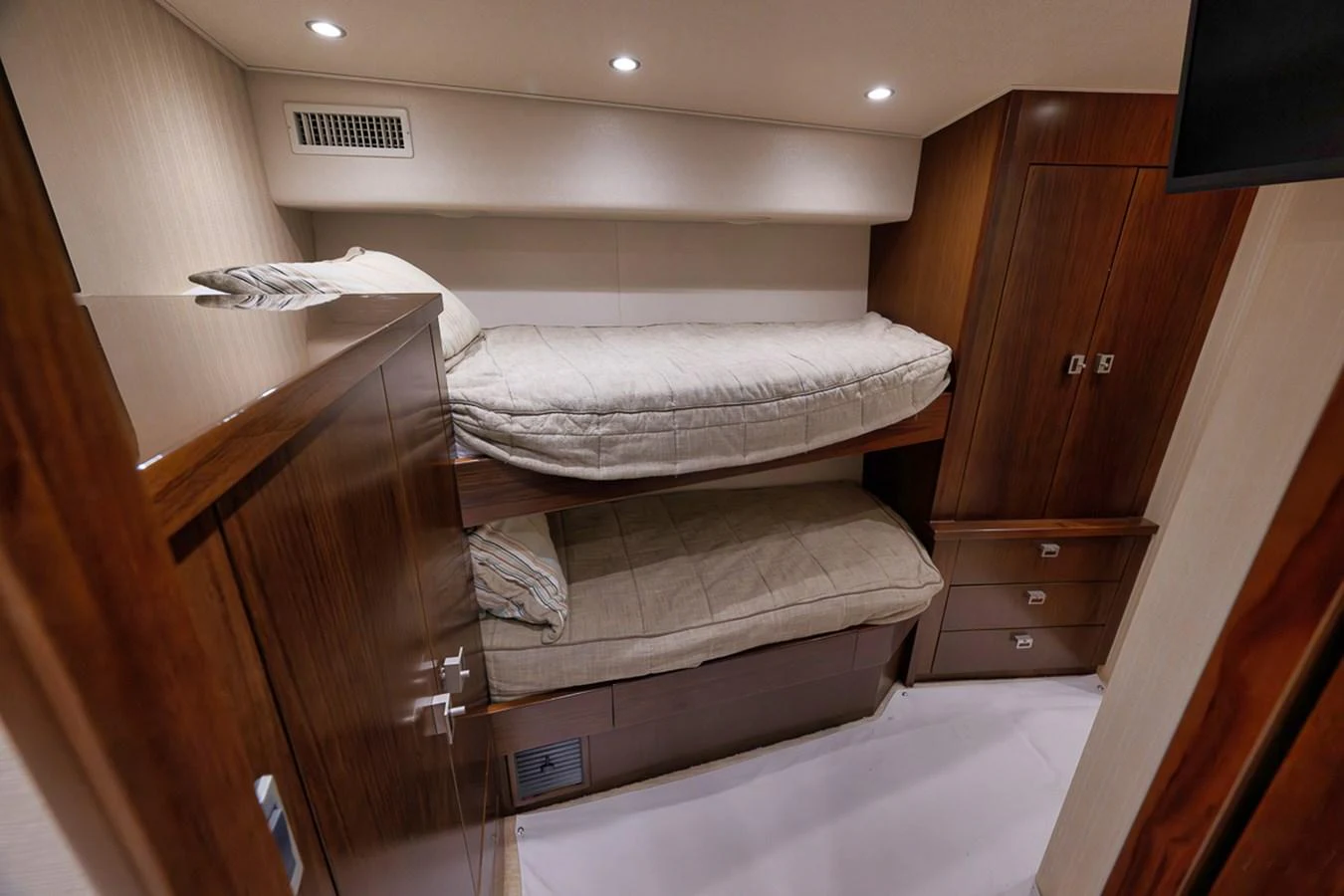 This cozy bunk room features two neatly made beds with wooden cabinetry and soft lighting. aboard REEL HAWK Yacht for Sale