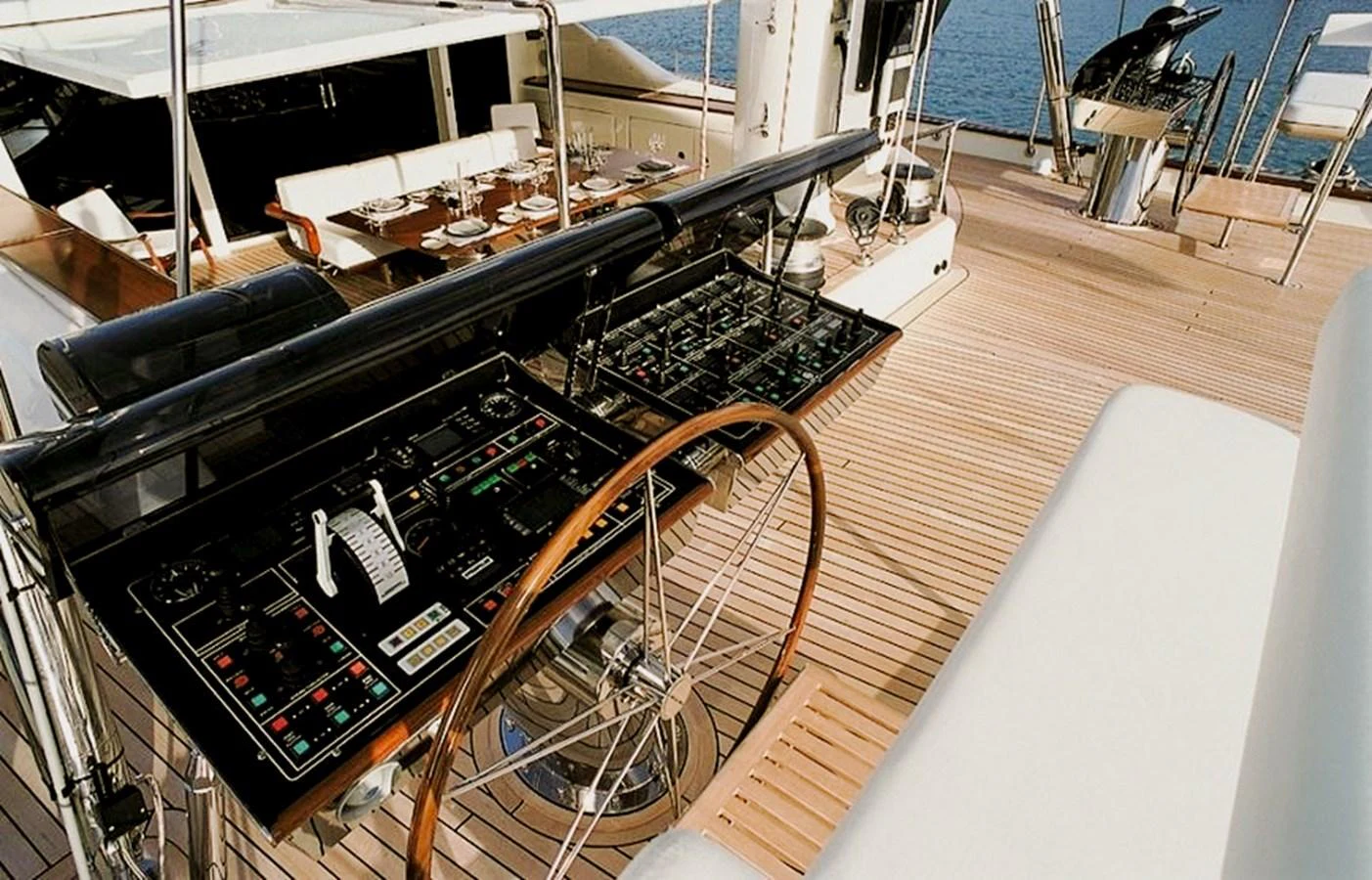 The helm station features sophisticated navigation equipment and a classic wooden steering wheel. aboard SQUALL Yacht for Sale