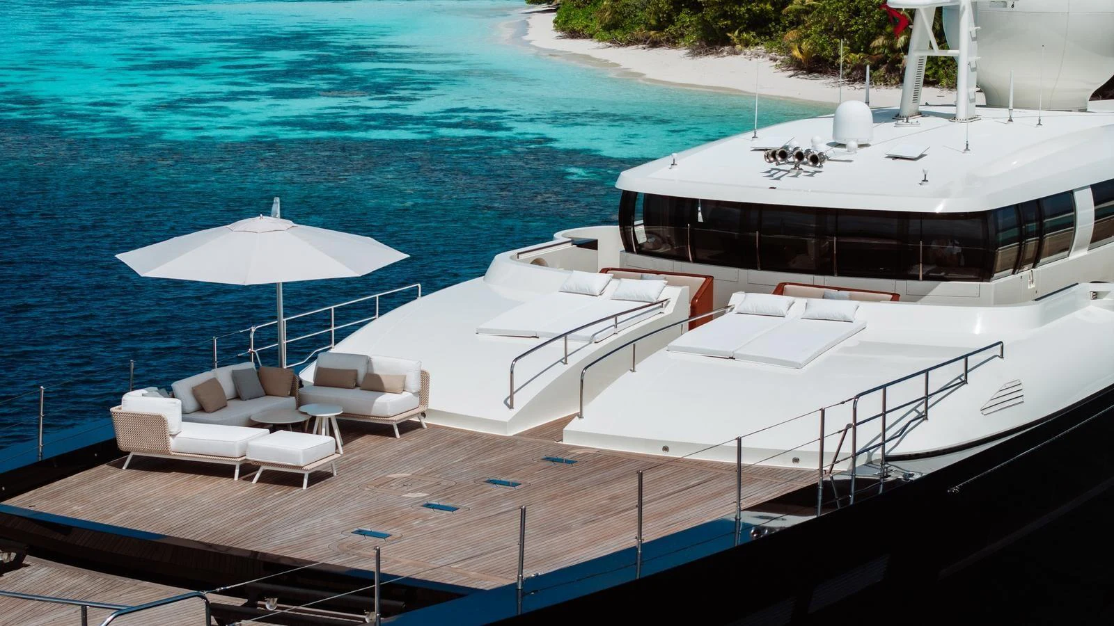 The yacht's foredeck features a spacious lounging area with plush seating and an umbrella, perfect for relaxation. aboard GALILEO Yacht for Sale