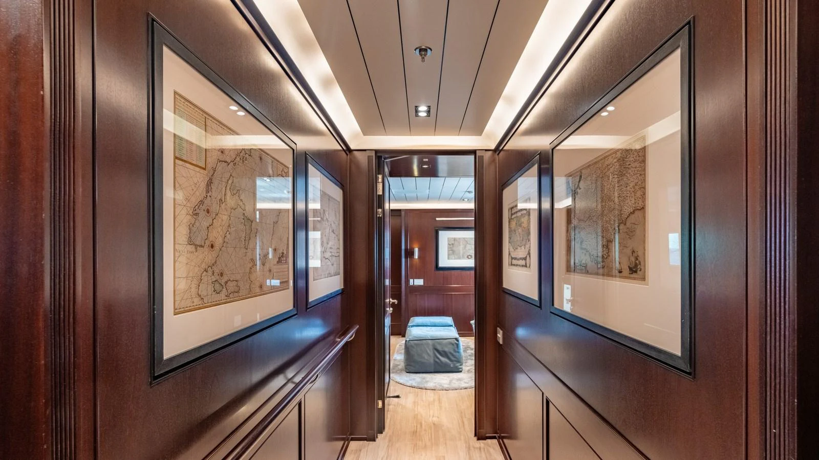 A luxurious hallway adorned with framed maps and rich wood paneling. aboard GALILEO Yacht for Sale