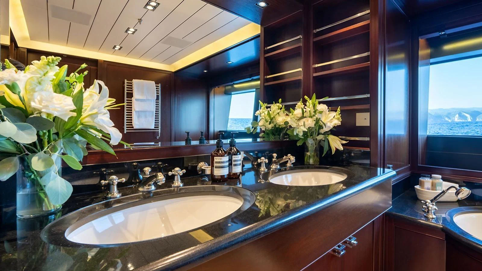 This luxurious yacht bathroom features dual sinks, elegant fixtures, and a stunning ocean view. aboard GALILEO Yacht for Sale