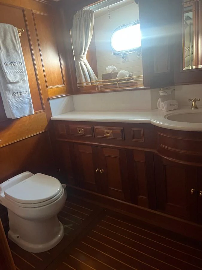The yacht's head features rich wooden cabinetry and a classic nautical design. aboard KNICKERBOCKER Yacht for Sale