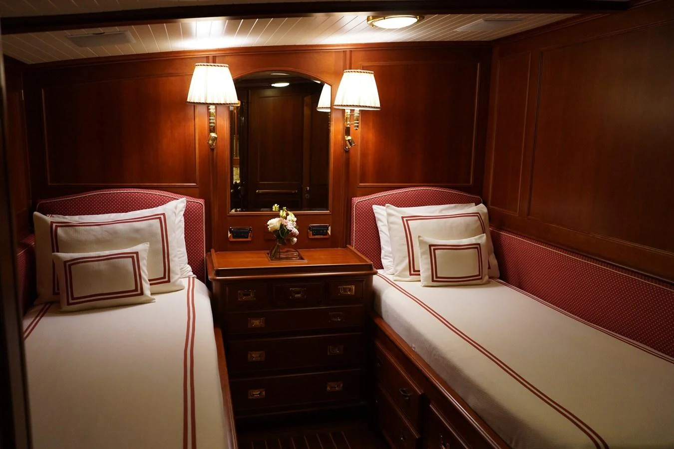 The twin stateroom features elegant wood paneling and cozy twin beds with classic bedding. aboard KNICKERBOCKER Yacht for Sale