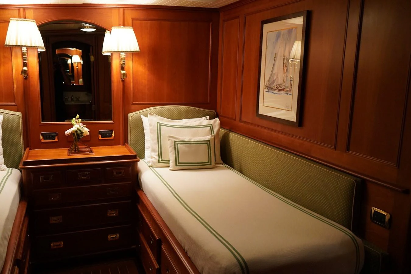 The guest cabin features twin beds with elegant wood paneling and soft lighting, creating a cozy and inviting atmosphere. aboard KNICKERBOCKER Yacht for Sale