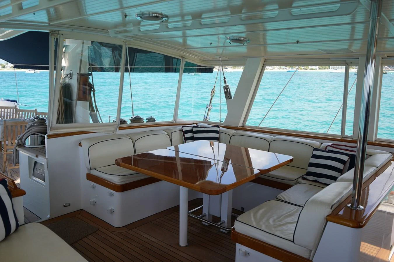 The yacht's saloon features a cozy seating area with a polished wooden table and plush cushions, offering a comfortable space to relax while enjoying the view of the water. aboard KNICKERBOCKER Yacht for Sale