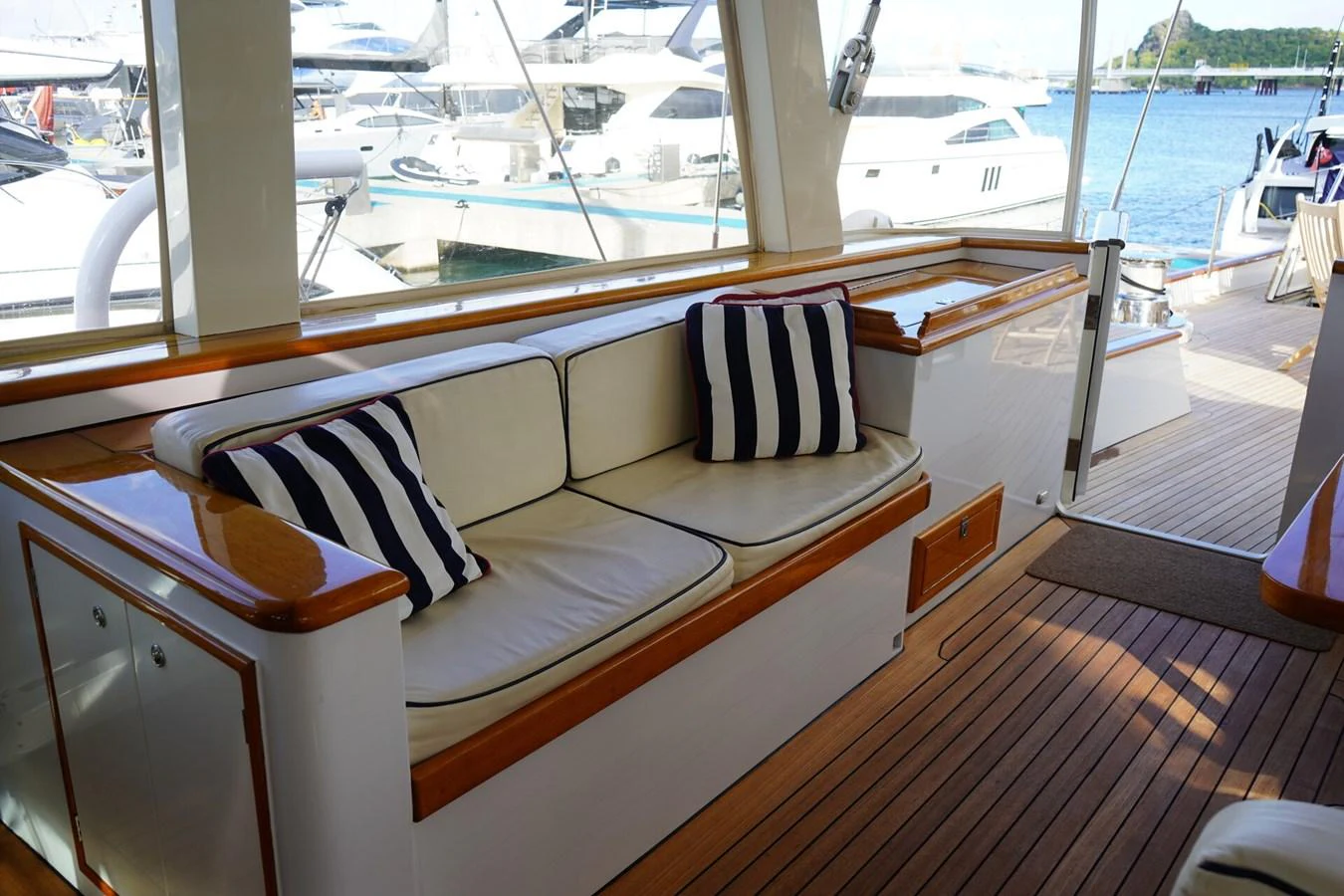 The aft deck features a comfortable seating area with striped cushions, perfect for relaxation. aboard KNICKERBOCKER Yacht for Sale
