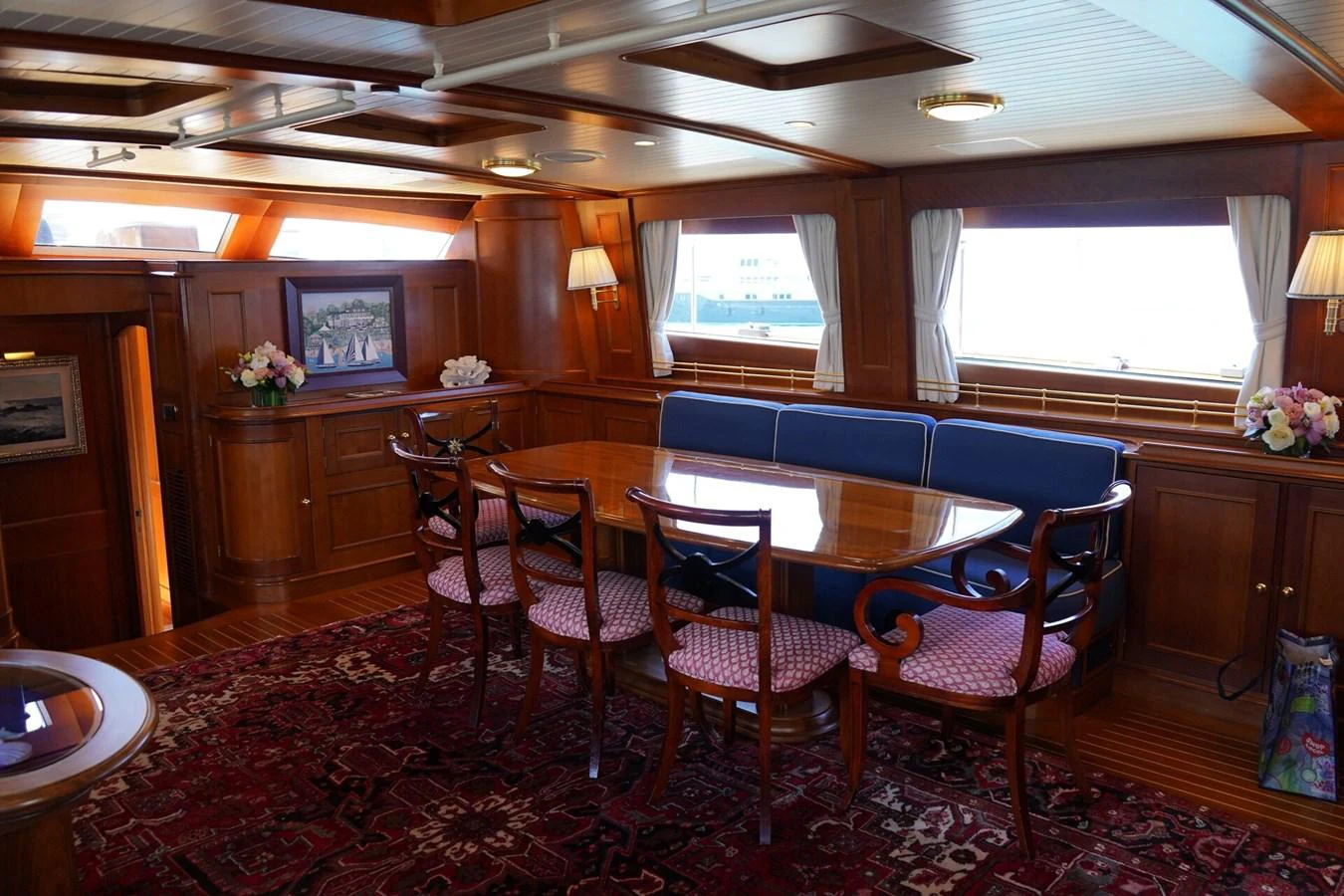 The yacht's dining area features elegant wooden furnishings and a cozy, inviting atmosphere. aboard KNICKERBOCKER Yacht for Sale