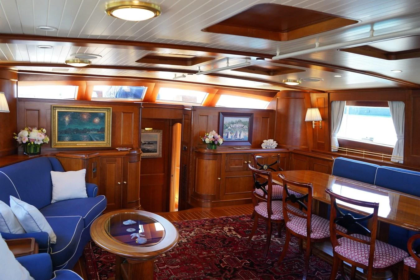 The yacht's salon features elegant wooden paneling, plush seating, and tasteful decor. aboard KNICKERBOCKER Yacht for Sale