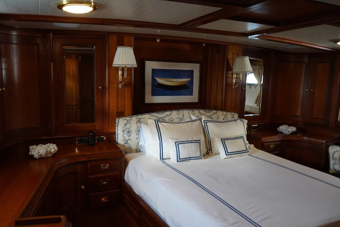 The stateroom features elegant wood paneling and a plush bed with nautical-themed linens. aboard KNICKERBOCKER Yacht for Sale