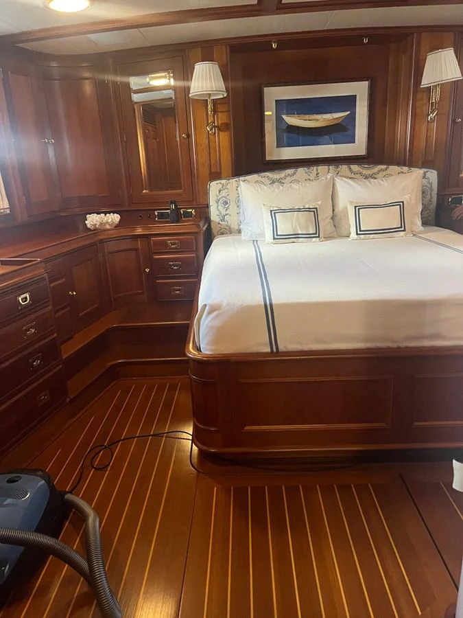 A luxurious stateroom featuring rich wooden cabinetry and a comfortable bed with elegant linens. aboard KNICKERBOCKER Yacht for Sale