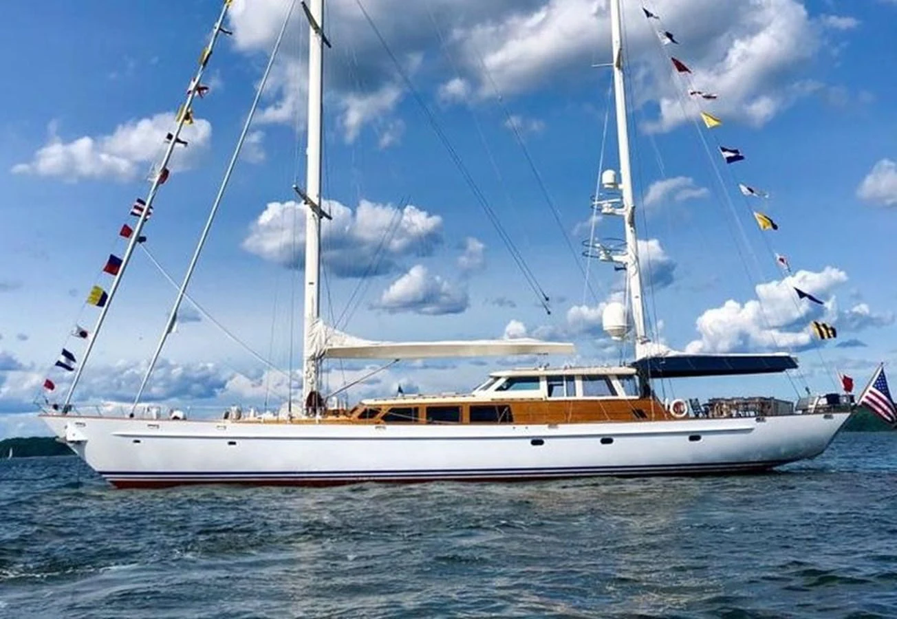 A stunning sailing yacht glides gracefully on the water under a clear blue sky. aboard KNICKERBOCKER Yacht for Sale