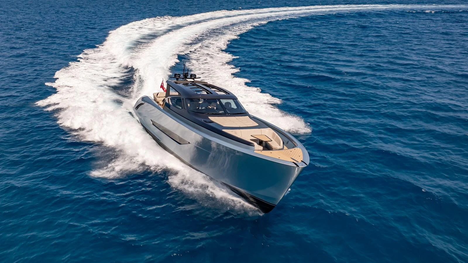 A sleek yacht glides swiftly across the open sea, leaving a dynamic wake behind. aboard RESOLUTE Yacht for Sale