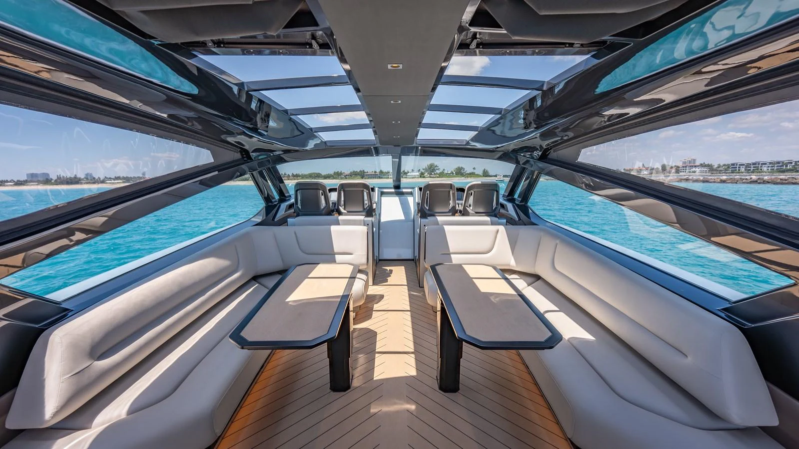 The yacht's saloon features expansive windows and luxurious seating with a panoramic view of the sea. aboard RESOLUTE Yacht for Sale