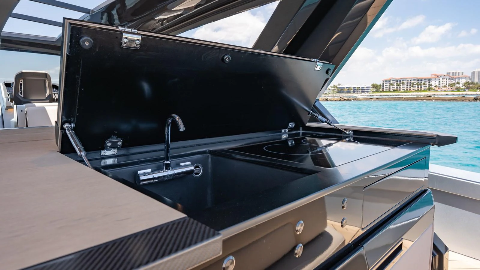 The yacht features a sleek outdoor galley with modern appliances and a stunning view of the water. aboard RESOLUTE Yacht for Sale