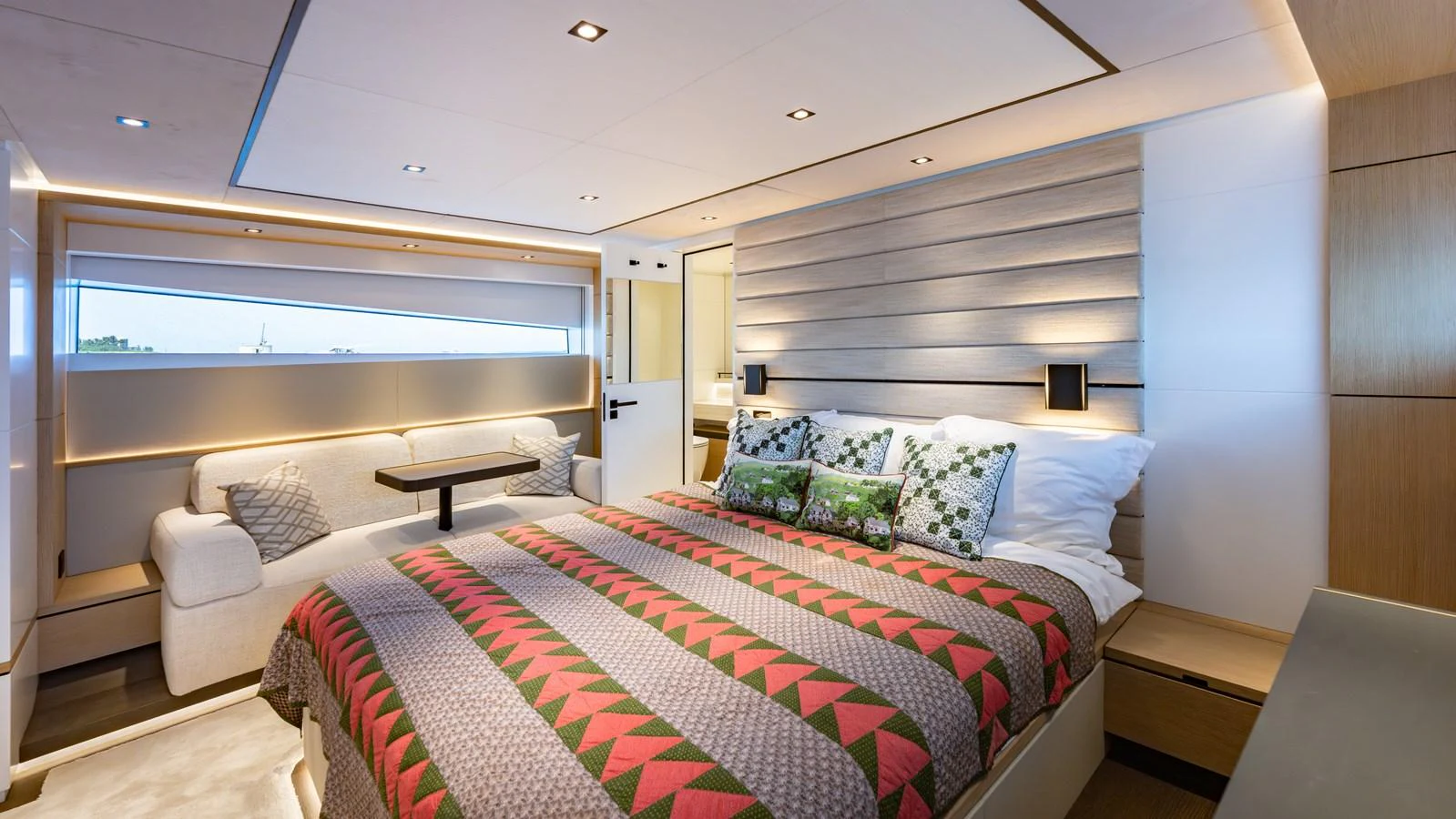 The master stateroom features a spacious bed, cozy seating area, and modern lighting. aboard RESOLUTE Yacht for Sale